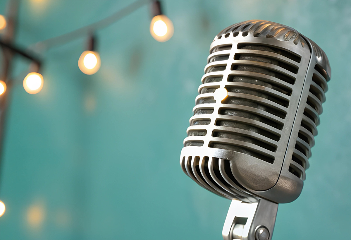 Old time microphone with a string of lights in the background.