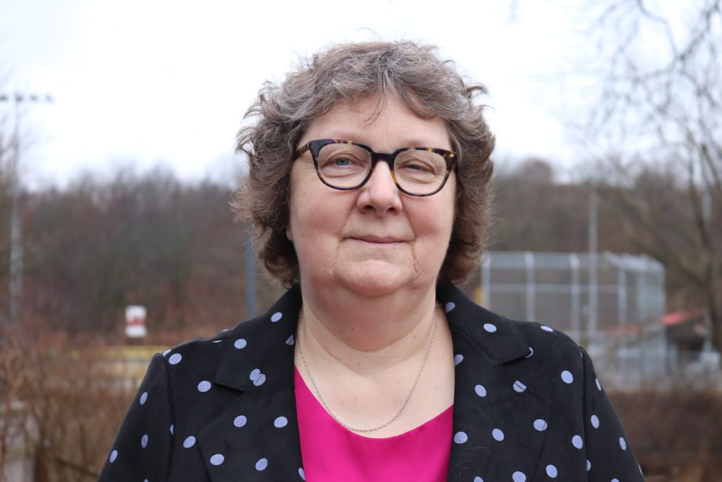 Karen McCall. A woman with short curly hair and glasses looking directly into the camera.